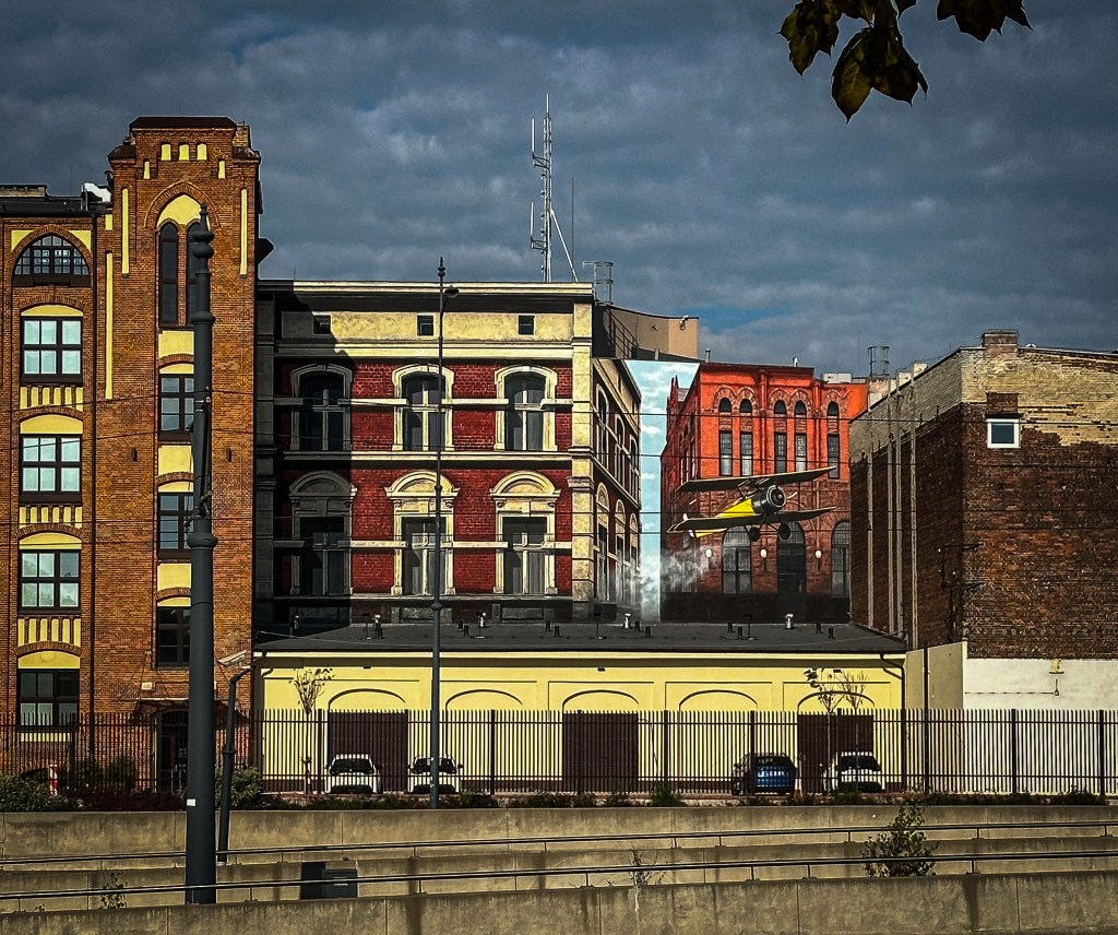 mural with plane and red factory buildings