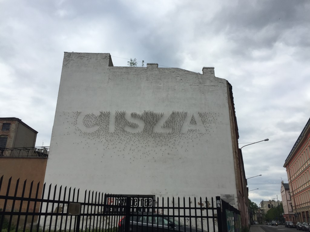 napis cisza na murze