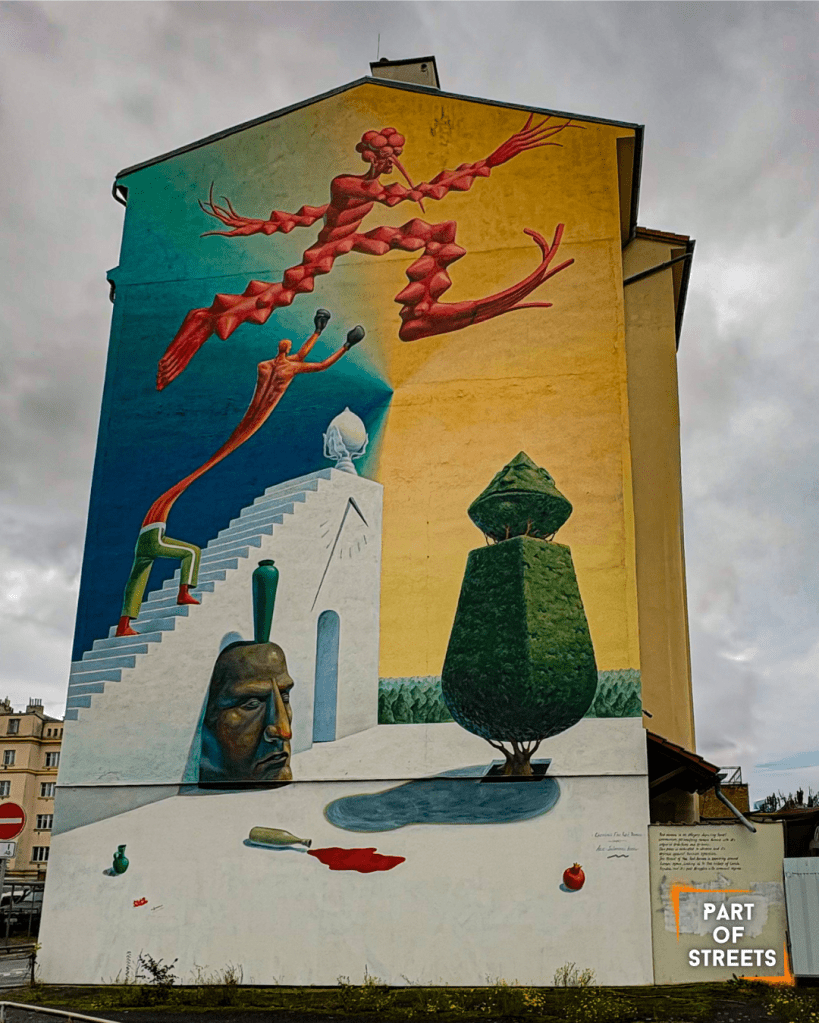 Surreal mural showing abstract human figures, a staircase with a face, and a sculpted tree against a blue and beige background on the side of a building.