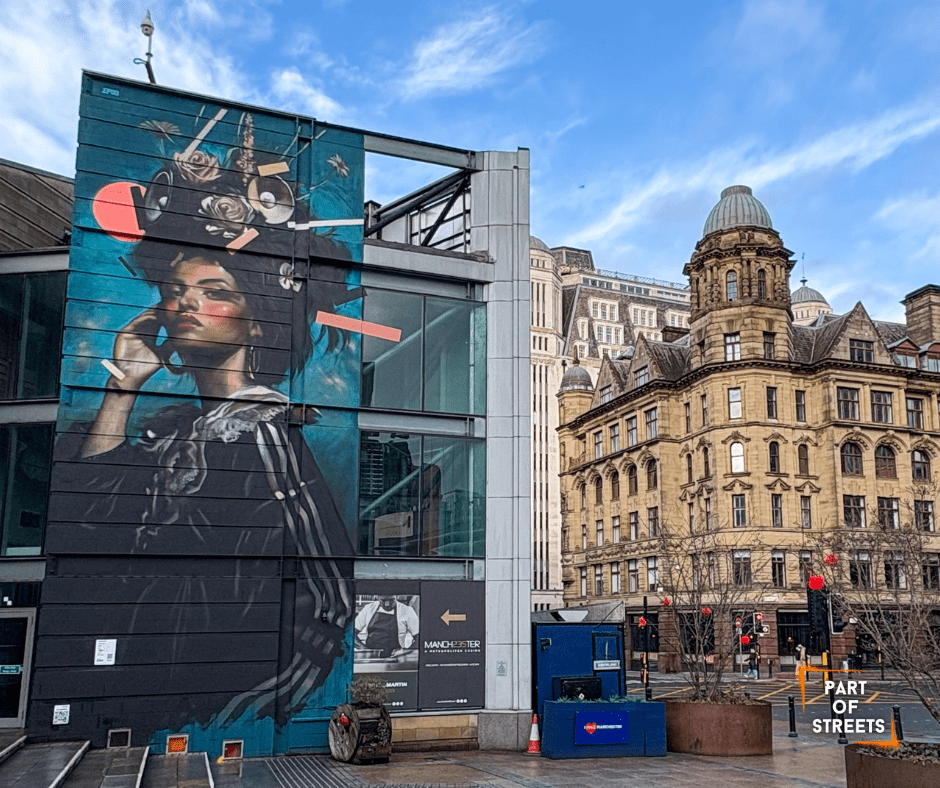 Mural by Epod in Manchester showing a stylish female portrait with surreal floral and geometric elements, painted on a modern building façade in the city centre.